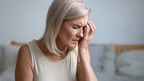 Woman carefully applying eye drops for lubrication, alleviating discomfort after vision procedure