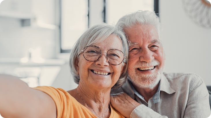 Portrait smiling elderly couple – happiness amplified by IOLs clarity.