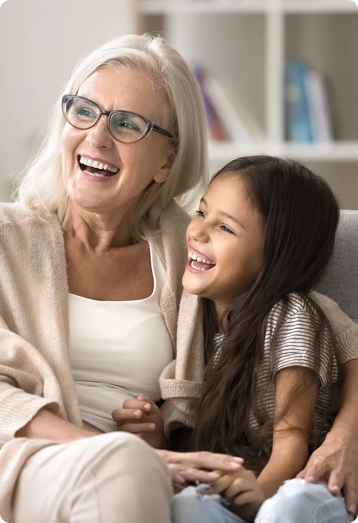 A woman plays with her granddaughter after having an eye exam and getting new glasses.